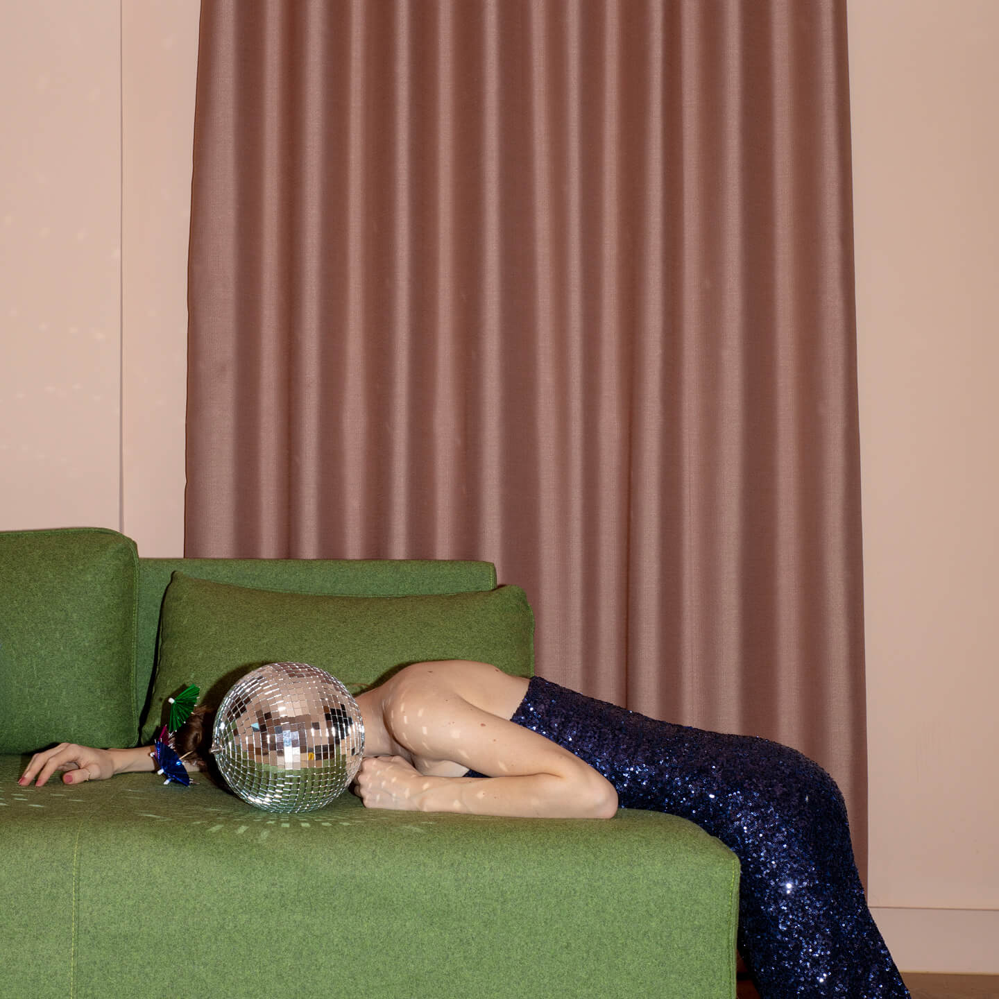 A person reclining on a sofa with a disco ball
