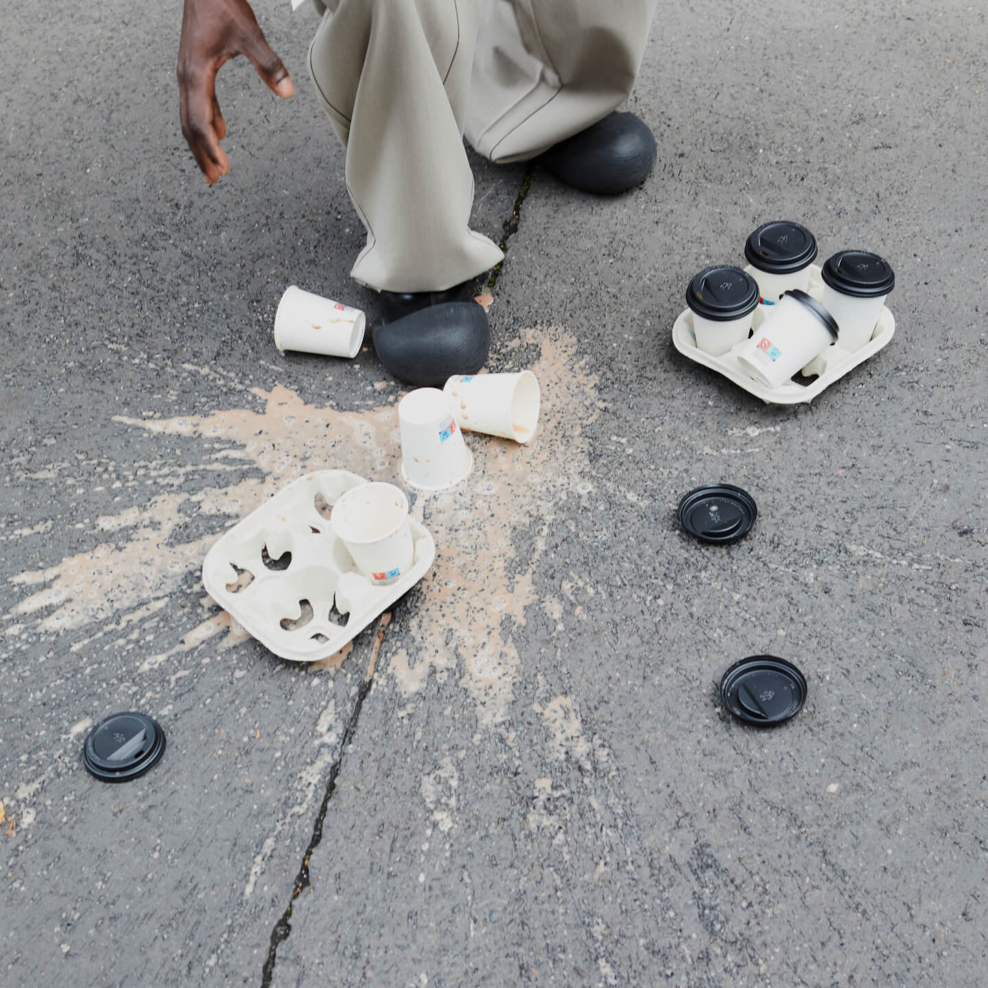 A spilled takeaway drink and food container on the pavement