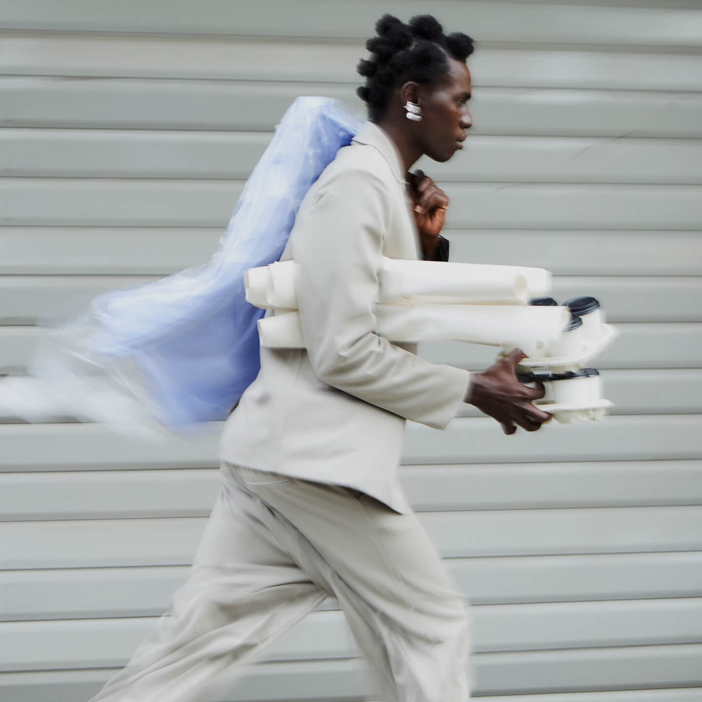 A person hurrying past with takeaway drinks